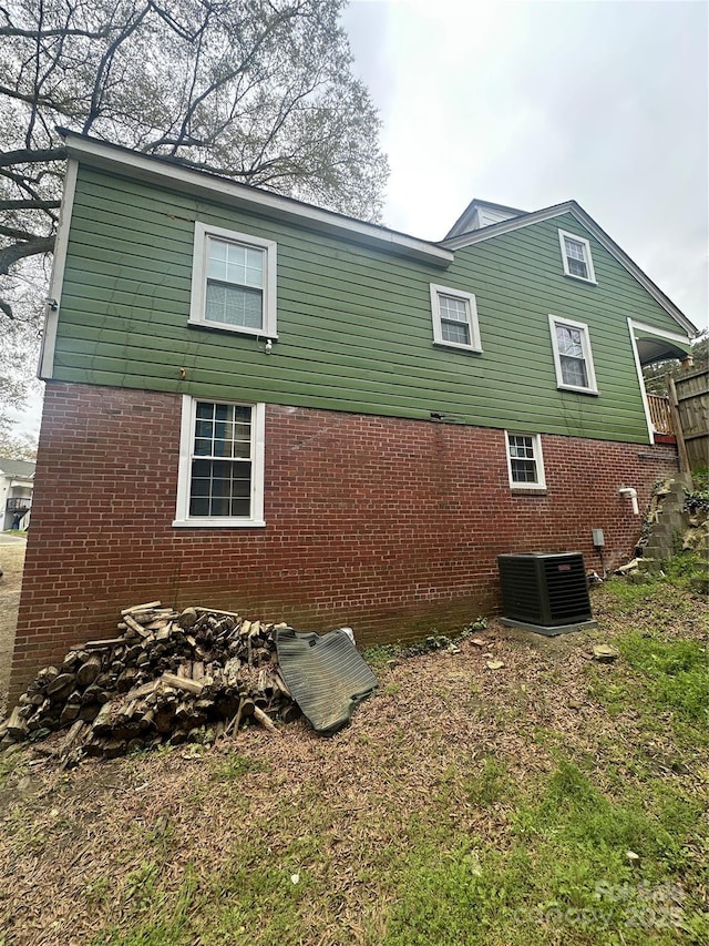 view of side of property featuring brick siding and cooling unit