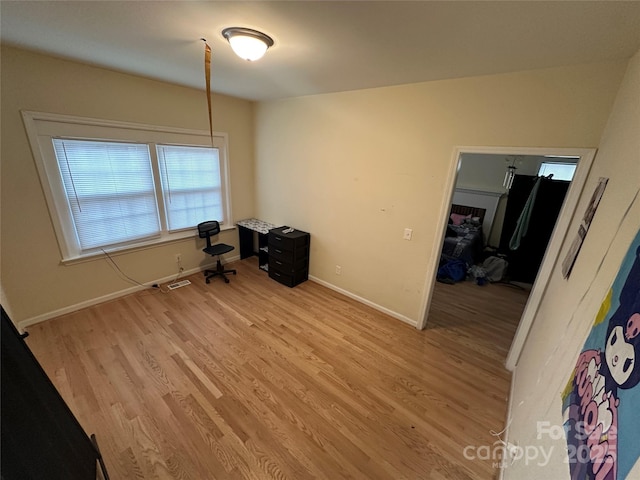 unfurnished office featuring baseboards, visible vents, and light wood-style floors
