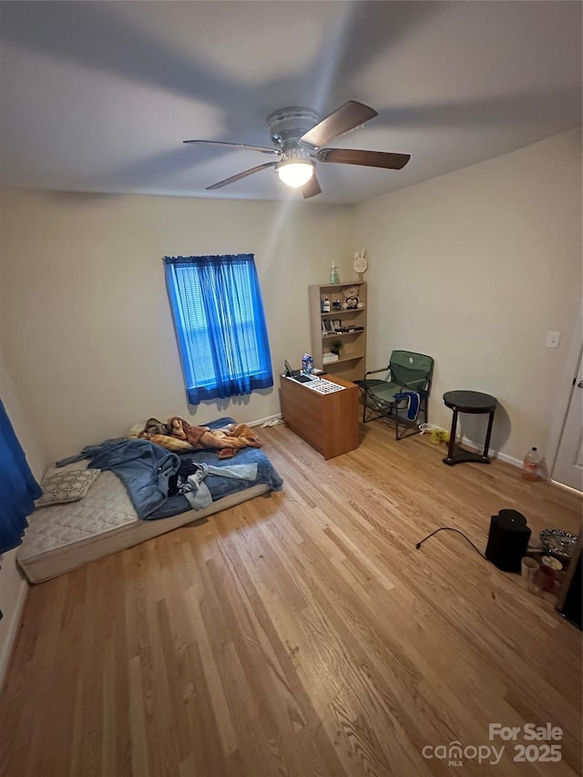 bedroom with baseboards, a ceiling fan, and wood finished floors