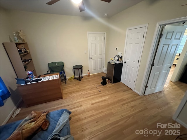 interior space featuring baseboards, ceiling fan, and light wood-style flooring