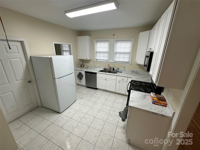 kitchen featuring appliances with stainless steel finishes, light stone countertops, a sink, white cabinets, and washer / dryer