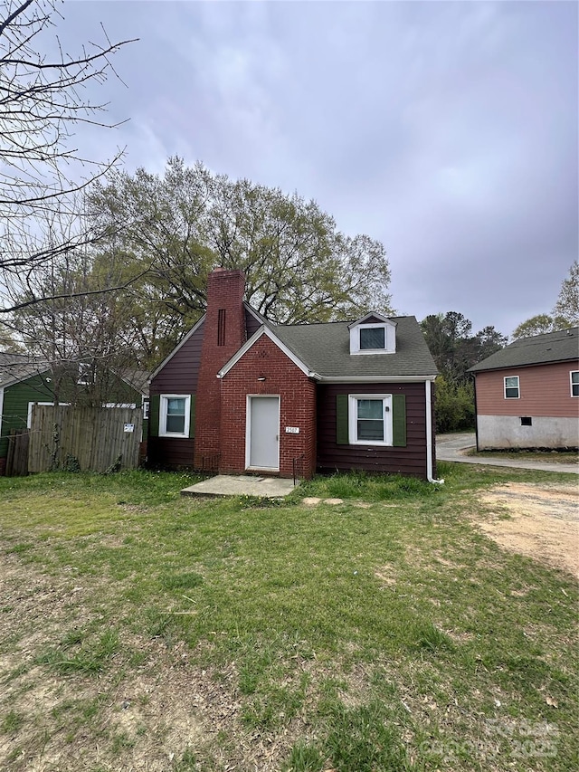view of front of home with a chimney and a front yard