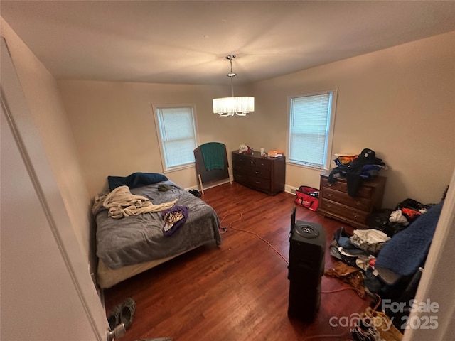 bedroom with multiple windows and wood finished floors