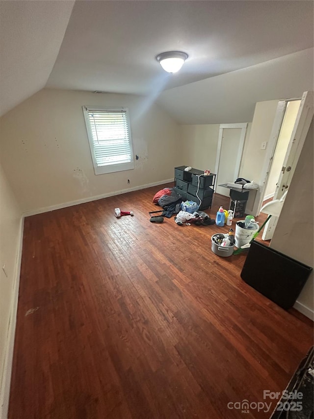 additional living space featuring wood finished floors, baseboards, and lofted ceiling
