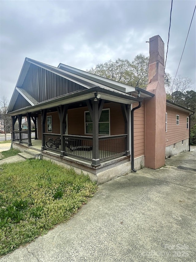 view of front of property featuring covered porch and a chimney