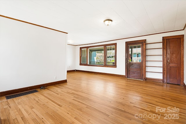 unfurnished living room featuring light wood-type flooring, visible vents, and ornamental molding