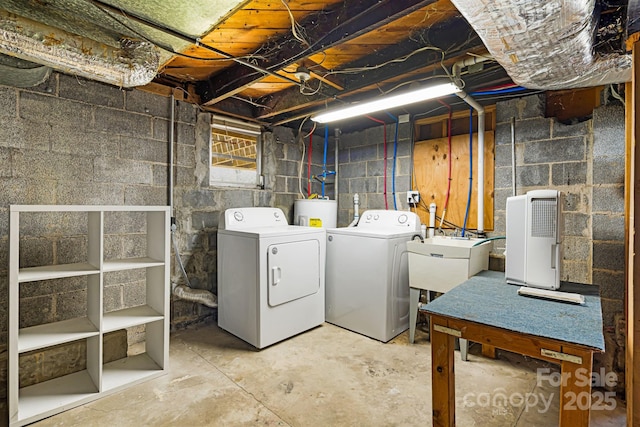 laundry area featuring water heater, independent washer and dryer, a sink, and laundry area