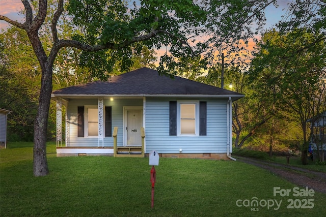bungalow featuring a yard, crawl space, and covered porch