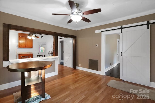 unfurnished dining area with baseboards, visible vents, and a barn door