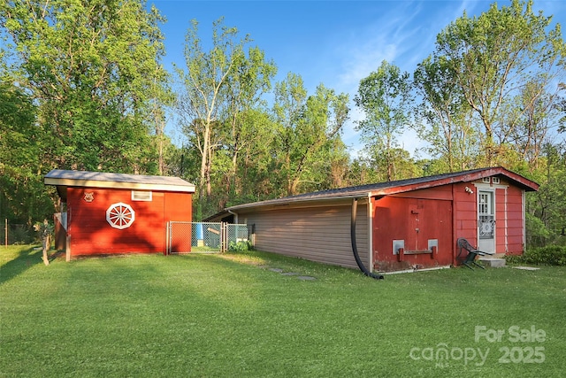 view of outbuilding featuring an outdoor structure, fence, and a gate