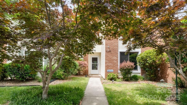 view of front facade with a front lawn and brick siding