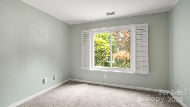 carpeted empty room featuring visible vents and baseboards