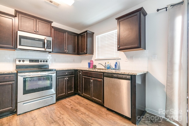 3033 Green Apple Dr, Dallas, NC 28034 - kitchen with tasteful backsplash, dark brown cabinetry, stainless steel appliances, light wood finished floors, and visible vents