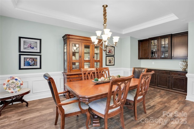 2655 Stonewood Vw, Kannapolis, NC 28081 - dining area featuring a raised ceiling, a chandelier, dark wood finished floors, ornamental molding, and a wainscoted wall