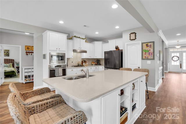 2655 Stonewood Vw, Kannapolis, NC 28081 - kitchen with appliances with stainless steel finishes, a sink, under cabinet range hood, a kitchen breakfast bar, and tasteful backsplash