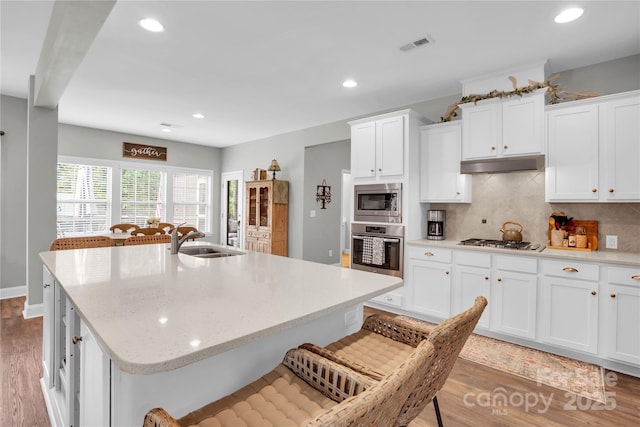 2655 Stonewood Vw, Kannapolis, NC 28081 - kitchen featuring appliances with stainless steel finishes, a sink, under cabinet range hood, light wood finished floors, and recessed lighting