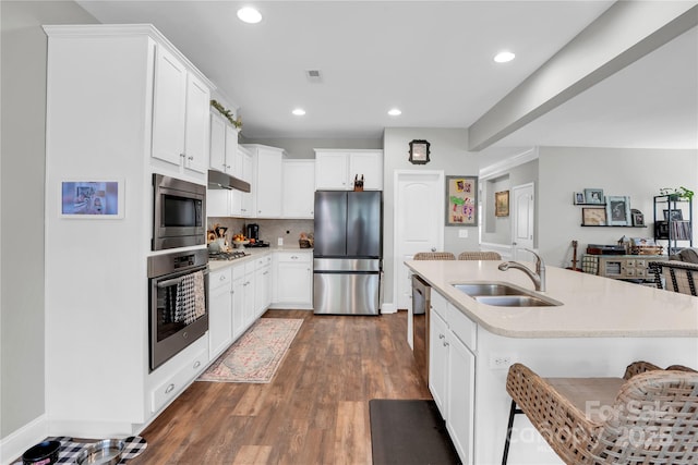 2655 Stonewood Vw, Kannapolis, NC 28081 - kitchen featuring appliances with stainless steel finishes, a sink, under cabinet range hood, light countertops, and tasteful backsplash