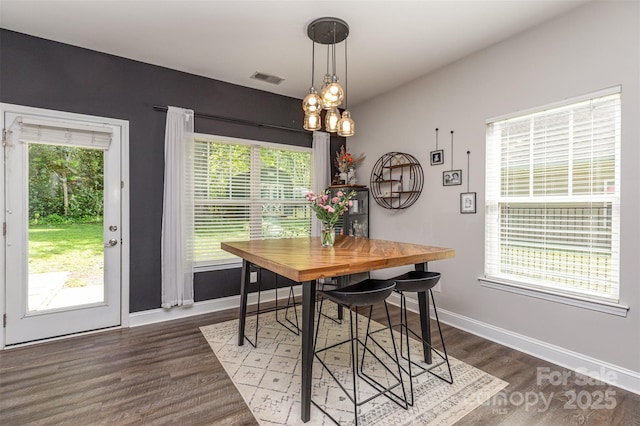 dining area with wood finished floors, a wealth of natural light, baseboards, and visible vents