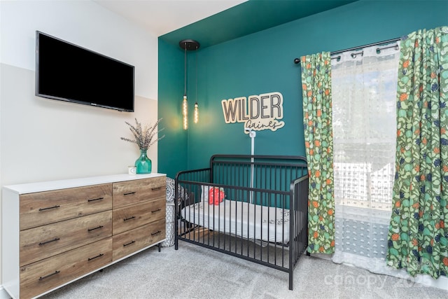 bedroom featuring carpet flooring and a nursery area