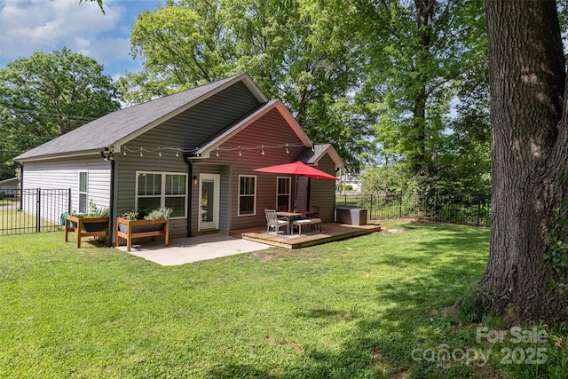 back of property featuring a lawn, fence, and a deck