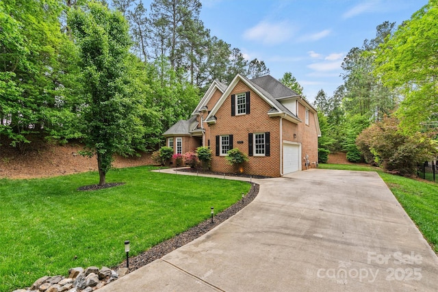 traditional home with brick siding, an attached garage, a front yard, and concrete driveway
