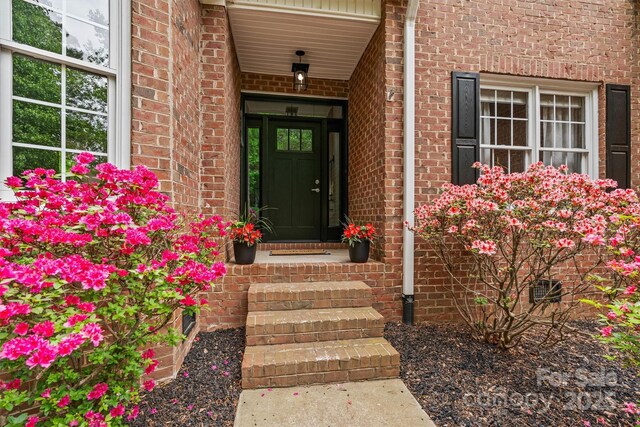 doorway to property with brick siding
