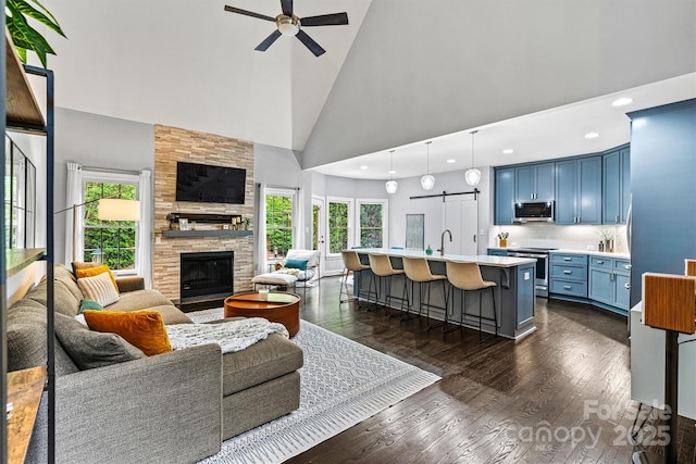living room featuring a wealth of natural light, high vaulted ceiling, dark wood-type flooring, and ceiling fan
