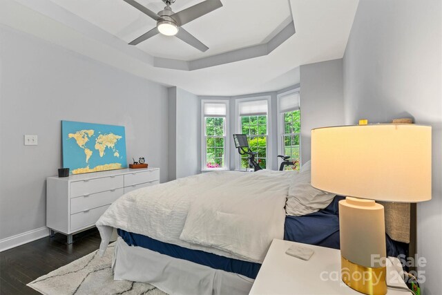 bedroom featuring dark wood-type flooring, a ceiling fan, and baseboards