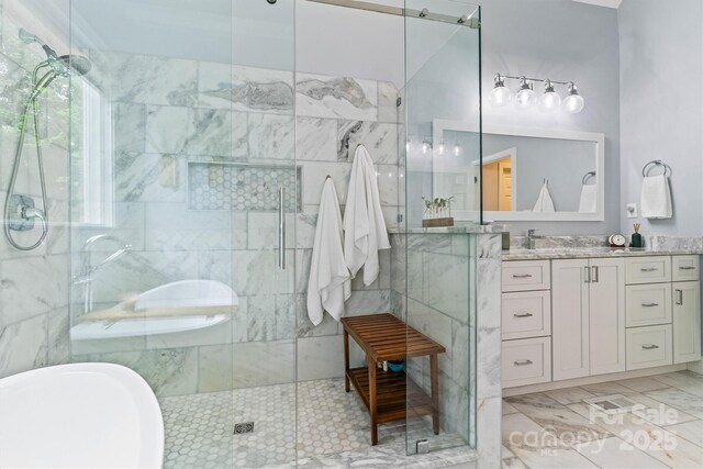 full bathroom with a soaking tub, vanity, and a stall shower