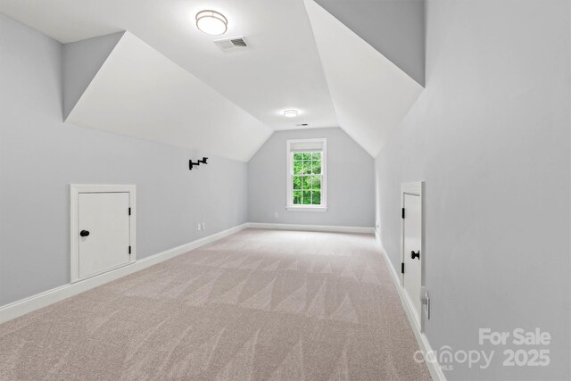 bonus room with lofted ceiling, carpet floors, visible vents, and baseboards