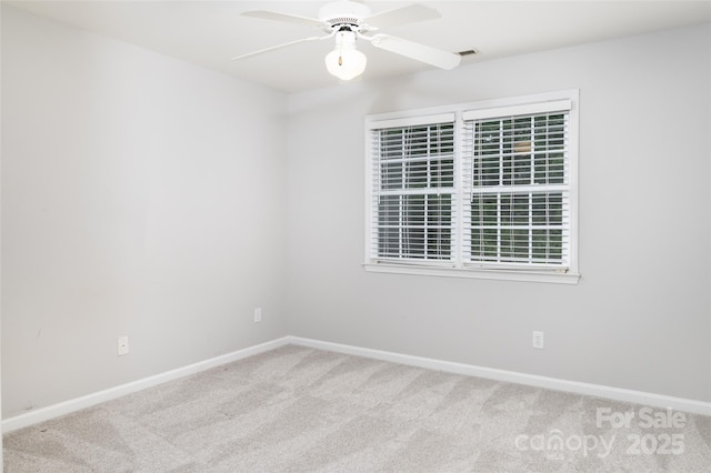 carpeted empty room featuring ceiling fan and baseboards