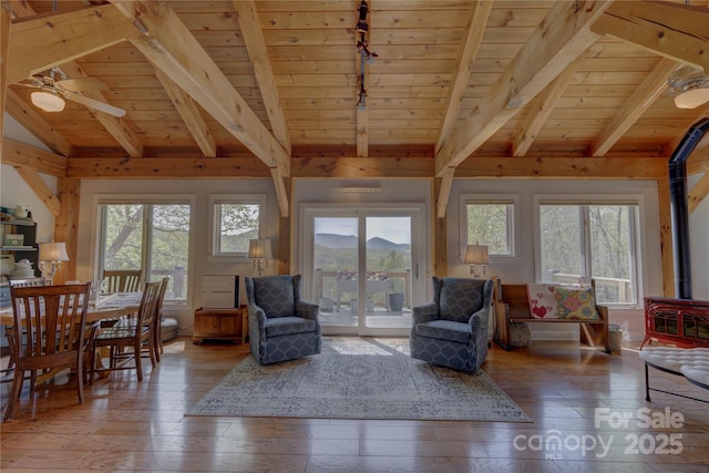 living area with track lighting, vaulted ceiling with beams, wood ceiling, hardwood / wood-style flooring, and ceiling fan