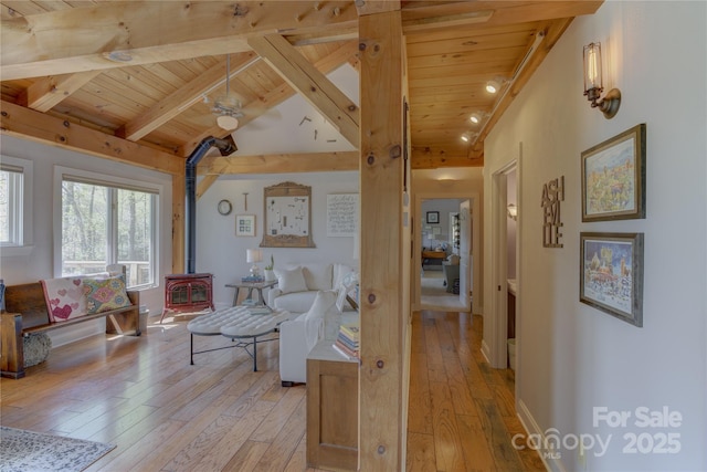 living room with wood ceiling, light wood-style flooring, and a wood stove