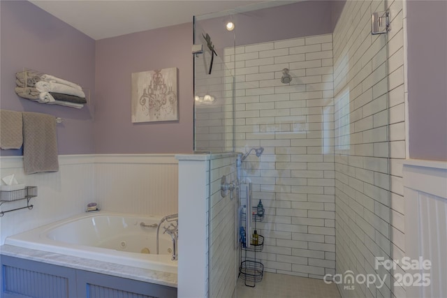 full bath featuring wainscoting, a shower stall, and a tub with jets