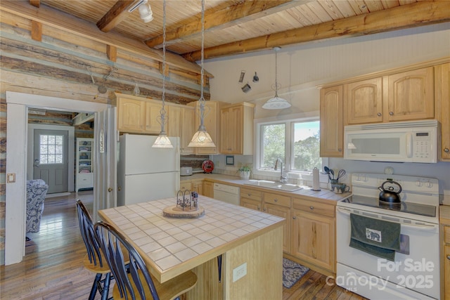 kitchen featuring light brown cabinetry, a wealth of natural light, a sink, white appliances, and tile counters