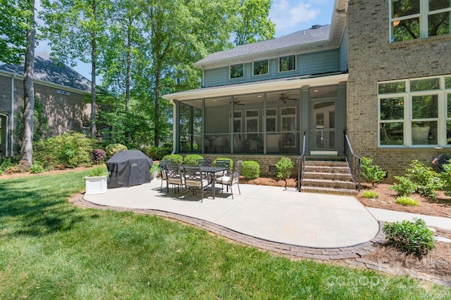 back of property with a sunroom, a ceiling fan, brick siding, a patio area, and a yard