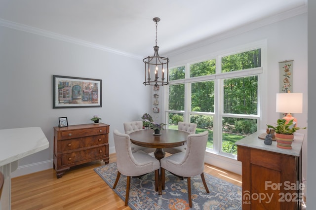 dining area featuring baseboards, ornamental molding, light wood finished floors, and a chandelier