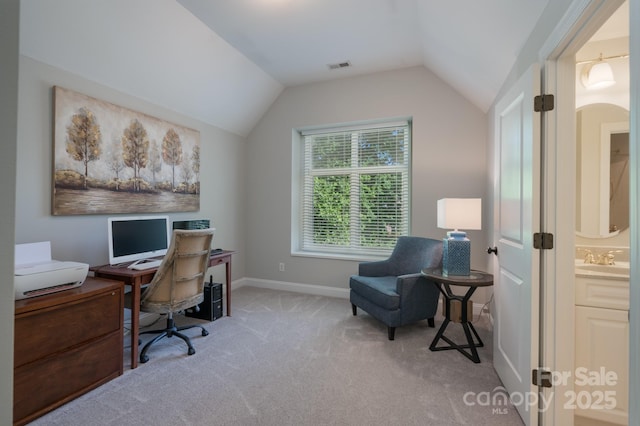 office space featuring a sink, carpet floors, baseboards, vaulted ceiling, and visible vents