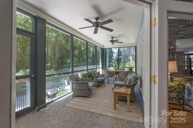 sunroom with plenty of natural light and a ceiling fan