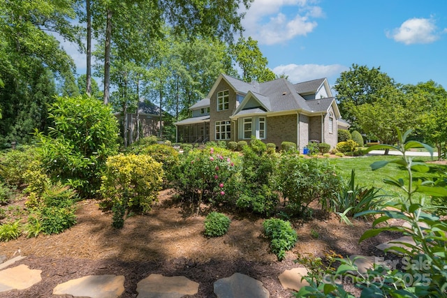 view of side of property featuring a sunroom and brick siding