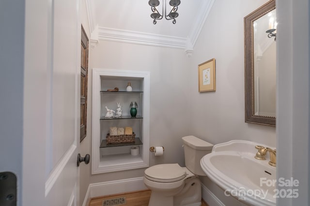 bathroom with visible vents, a sink, baseboards, toilet, and ornamental molding