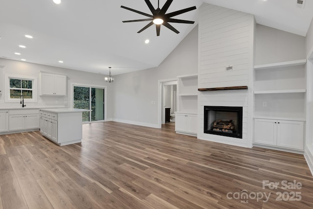 252 Big Lick Rd, Stanfield, NC 28163 - unfurnished living room featuring ceiling fan with notable chandelier, a fireplace, a sink, and recessed lighting