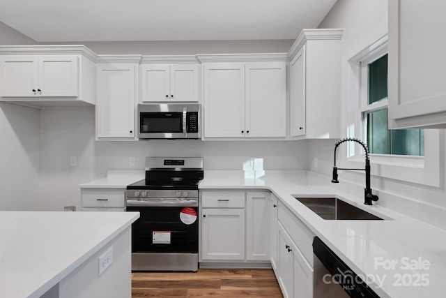 252 Big Lick Rd, Stanfield, NC 28163 - kitchen with appliances with stainless steel finishes, a sink, white cabinetry, and light wood-style flooring