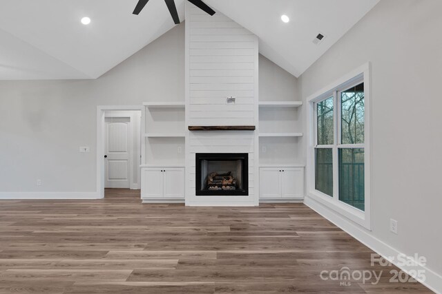 252 Big Lick Rd, Stanfield, NC 28163 - unfurnished living room featuring a fireplace, baseboards, high vaulted ceiling, and ceiling fan