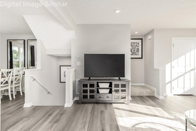 living area with wood finished floors, baseboards, and recessed lighting