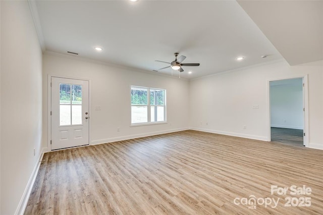 unfurnished living room with light wood-style floors, a healthy amount of sunlight, ornamental molding, and ceiling fan