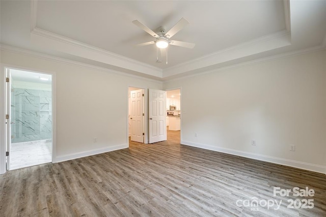 spare room featuring ceiling fan, wood finished floors, and a raised ceiling