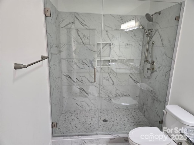 bathroom with marble finish floor, a shower stall, and toilet