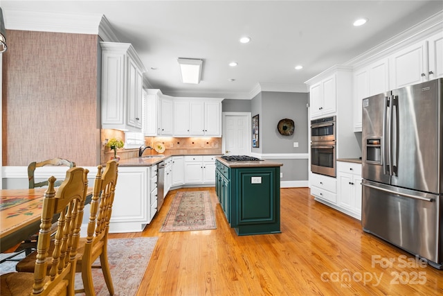 3420 Maryhurst Ln, Charlotte, NC 28226 - kitchen with appliances with stainless steel finishes, white cabinets, a kitchen island, crown molding, and a sink