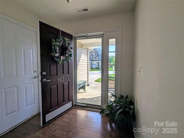 foyer entrance featuring visible vents and dark wood-type flooring